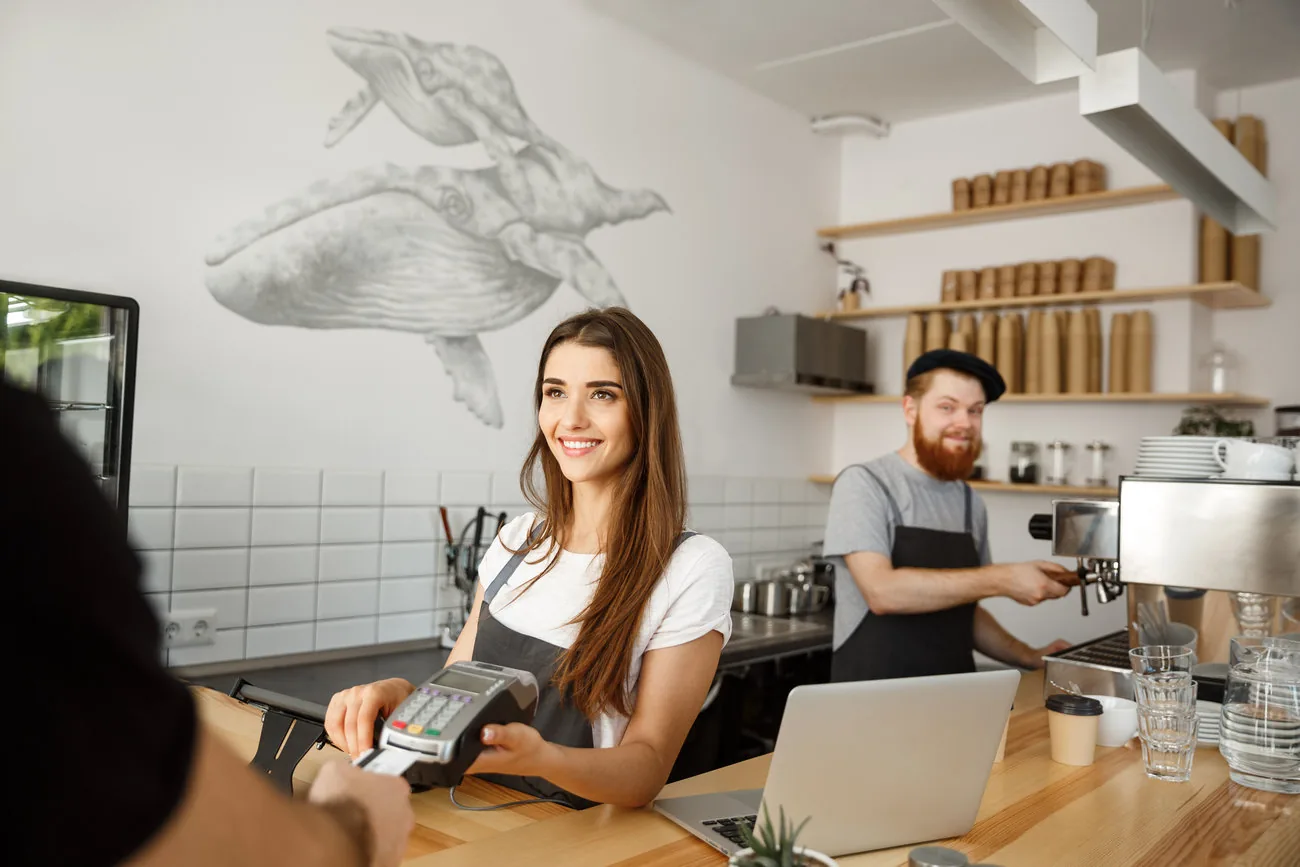 Emprendedora atendiendo a un cliente en una cafetería.