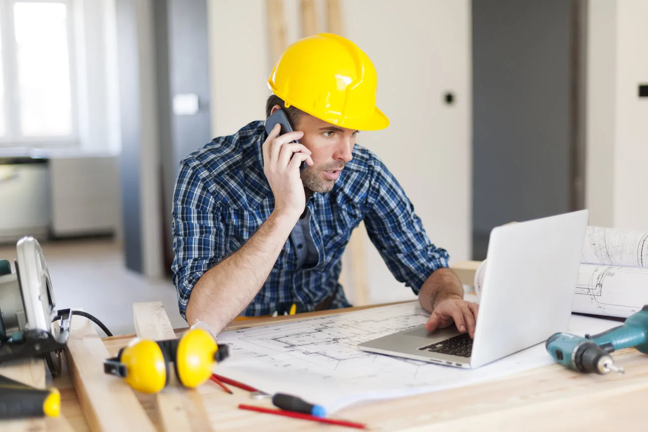 Profesional de una empresa contratista coordinando administración y trabajo desde una obra.