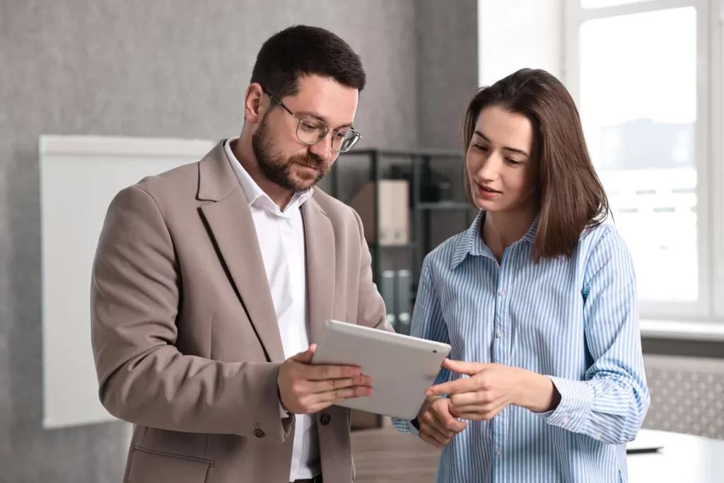 Consultor revisando información con una clienta en una oficina.