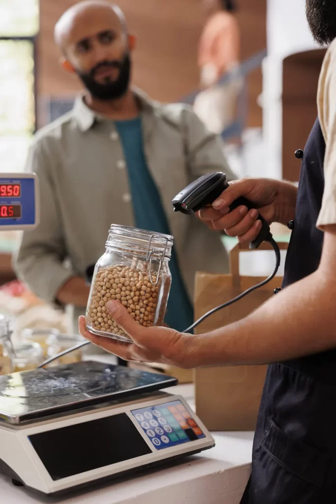 Trabajador registrando un producto con lector en un comercio.