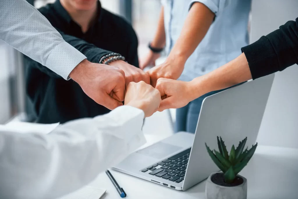 Equipo de trabajo celebrando un resultado en una oficina.