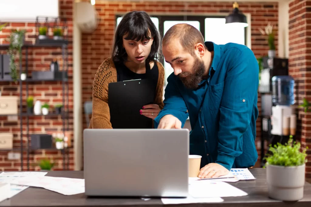 Equipo de empresa revisando documentos y planificación en un pequeño negocio.