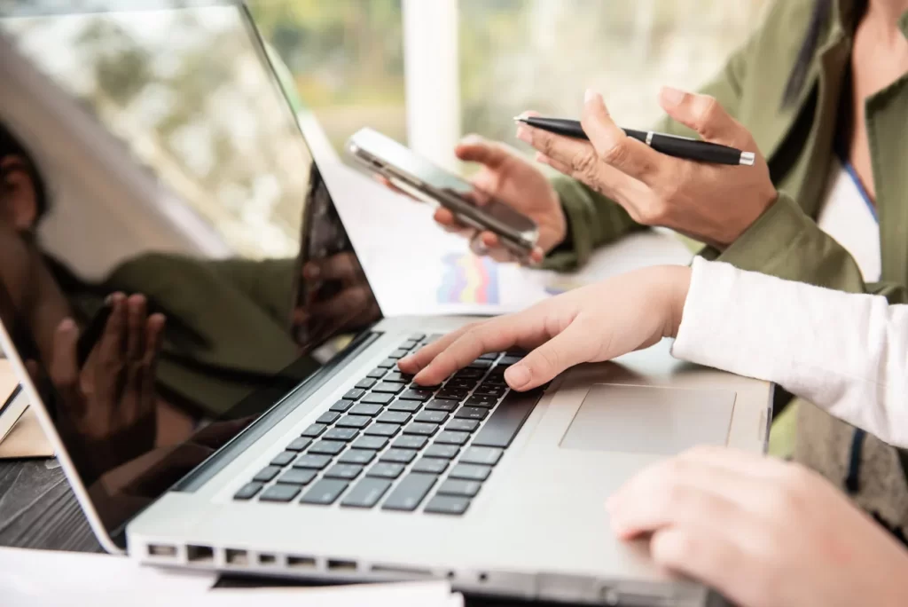 Profesionales trabajando con computador, tablet y documentación financiera.
