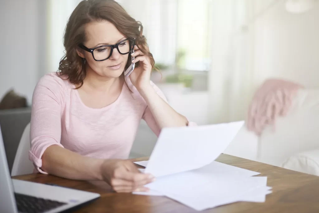 Profesional trabajando desde casa y hablando por teléfono.