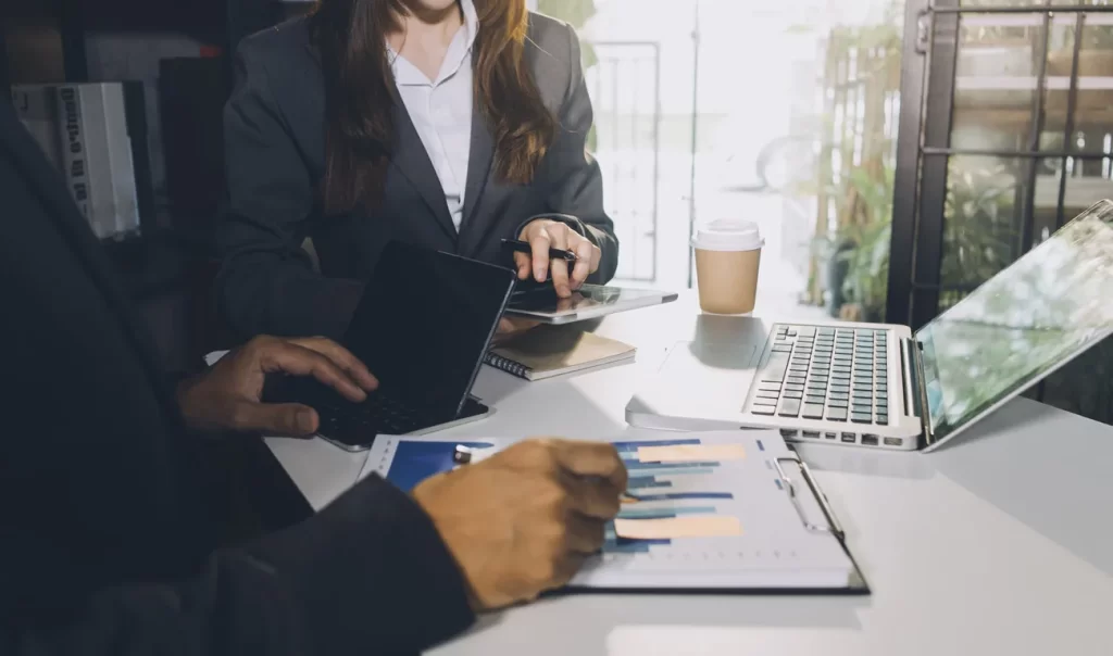 Equipo de empresa revisando información financiera y trabajando con computadores.