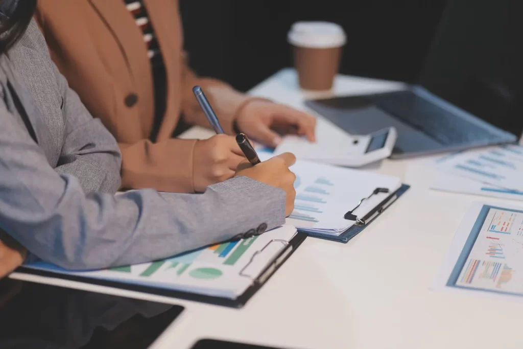 Equipo empresarial analizando gráficos y documentación financiera.