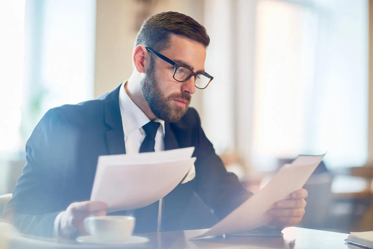 Profesional revisando documentos y correspondencia en una oficina.